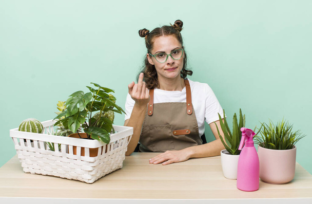 young pretty woman  feeling angry, annoyed, rebellious and aggressive. gardering plants concept - Фото, изображение