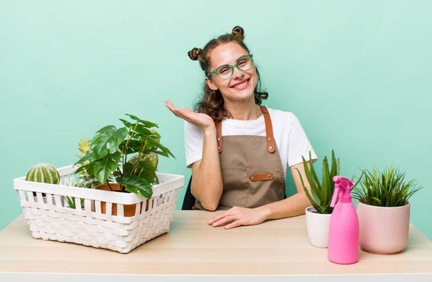 young pretty woman  smiling cheerfully, feeling happy and showing a concept. gardering plants concept - Photo, Image