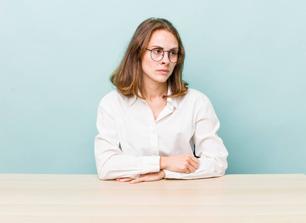 young pretty woman  feeling sad, upset or angry and looking to the side. desk and business concept - Photo, image