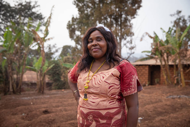 Porträt einer 50-jährigen Afrikanerin in einem afrikanischen Kleid im Freien - Foto, Bild