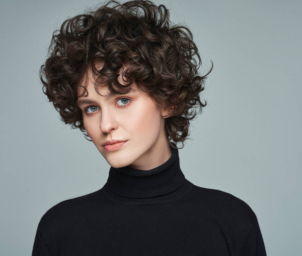 Portrait of brunette with curls wear turtleneck jumper over grey background - Photo, Image