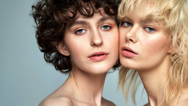 Studio portrait of two sensual young women with clean fresh face skin and perfect nude makeup - Foto, Imagem