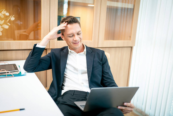 Podnikatel se během svého pracovního dne v kanceláři dívá na monitor počítače. Obchodní a úspěšná koncepce - Fotografie, Obrázek