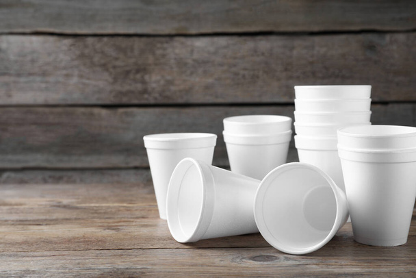 Many white styrofoam cups on wooden table, space for text - Foto, Bild