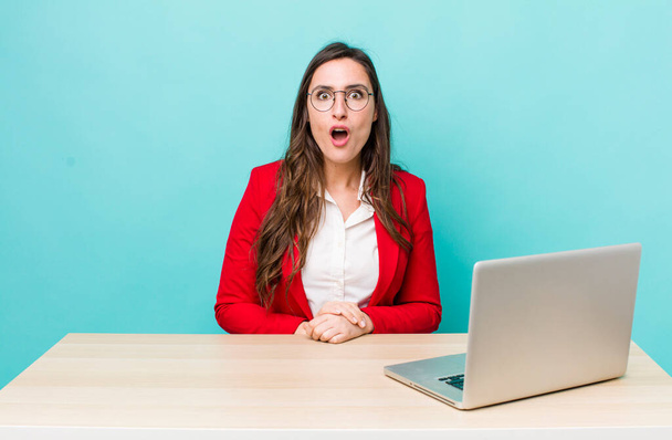 young pretty woman  looking very shocked or surprised. business desk concept - Photo, image