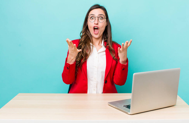 young pretty woman  feeling extremely shocked and surprised. business desk concept - Photo, image