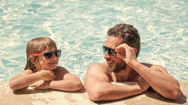 Kindheit und Elternschaft. Freundschaft. Vater und Sohn tragen Brille im Schwimmbadwasser - Foto, Bild
