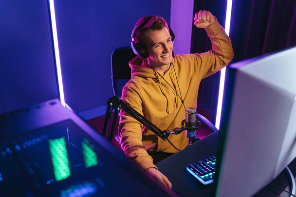 Happy professional gamer streaming his video game at home - Fotó, kép