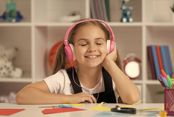 kind in een moderne koptelefoon. online onderwijs. terug naar school. gelukkig tiener meisje in hoofdtelefoon. - Foto, afbeelding