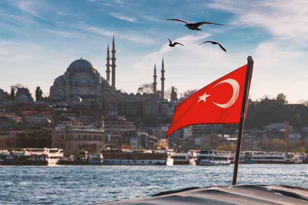 ボスポラス船、モスク、トルコのイスタンブールのミナレットにトルコの旗 - 写真・画像