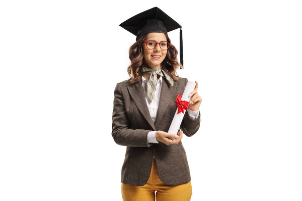 Bachelor female student with a graduation hat holding a diploma isolated on white background - Foto, Imagen