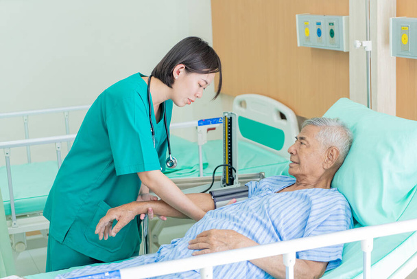 Asian nurse blood pressure monitor grandfather in hospital., Medical and healthcare concept. - 写真・画像