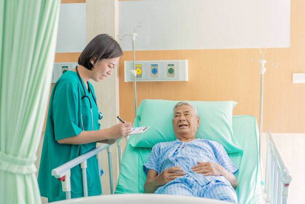 Ázsiai nővér gondozása idősebb ázsiai férfi és beszél az egészségét a kórházban., Orvosi és egészségügyi koncepció. - Fotó, kép