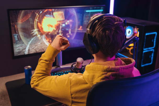Profi-Gamer mit Kopfhörern feiert seinen Sieg bei Online-E-Sport-Turnier - Foto, Bild