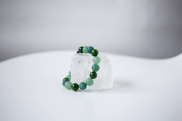 Perles de pierres naturelles multicolores reposent sur une pierre blanche neige, topaze et quartz - Photo, image