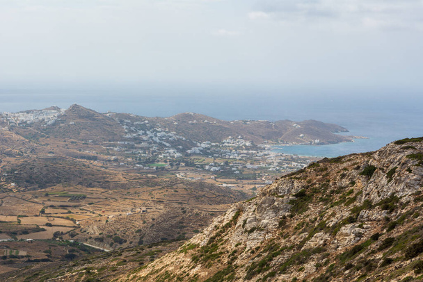 Uitzicht op de wazige westkust van het eiland Ios. Chora stad en haven op de achtergrond. Cycladen, Griekenland - Foto, afbeelding