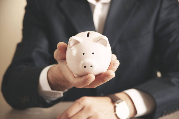 Man putting coin in piggy bank. saving money, finance concept - Valokuva, kuva