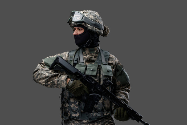 Храбрый армеец с огнестрельным ружьем смотрит в сторону - Фото, изображение