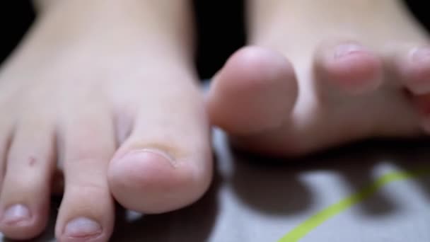 Close-up Tired Child Wiggles his Toes while Lying on the Bed in Room. Zoom - Metraje, vídeo