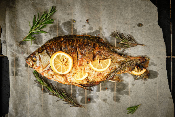 Cooked on parchment paper, baked fish with spices, lemon and rosemary - Foto, Bild