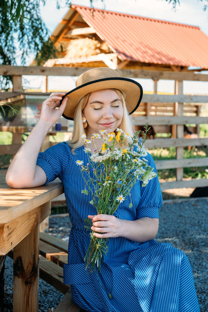 Cottages at Summer Village, Vacation Rentals. Domestic Travel, Local Travel, Summer Country Travel. Countryside Getaways. Young woman in straw hat enjoys summer vacation at the farm - Foto, immagini