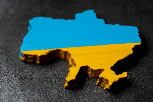 map of Ukraine carved from wood and painted in the colors of the Ukrainian flag - Foto, afbeelding