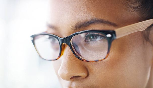 Eyes fully focused on the prize. Closeup shot of an attractive young businesswoman wearing spectacles in a modern office. - Fotografie, Obrázek