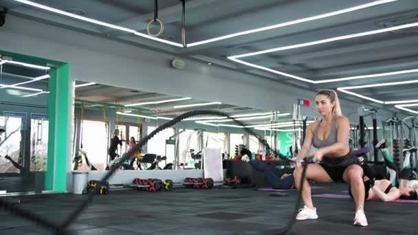 CrossFit Blond žena trénuje s provazy Protahuje svaly Hrát sport - Záběry, video