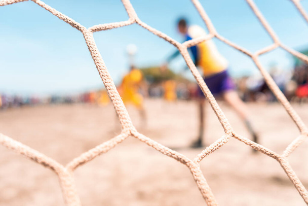 Nierozpoznawalny bramkarz rzucający piłkę podczas meczu piłki nożnej na plaży w Masachapa, Nikaragua. Koncepcja popularnego sportu w Ameryce Łacińskiej. - Zdjęcie, obraz