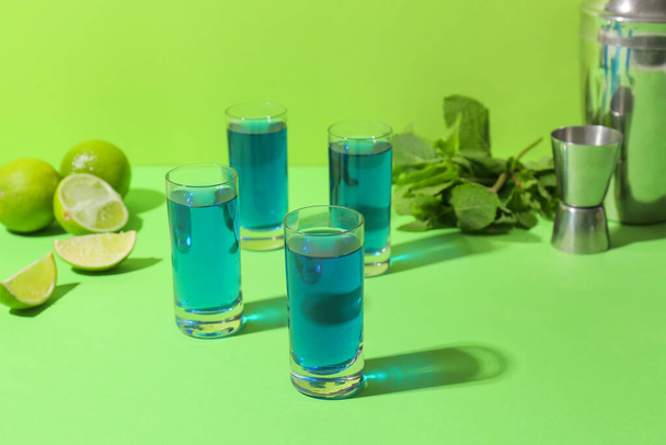 Shot cocktails, limes and mint on color background - Фото, изображение