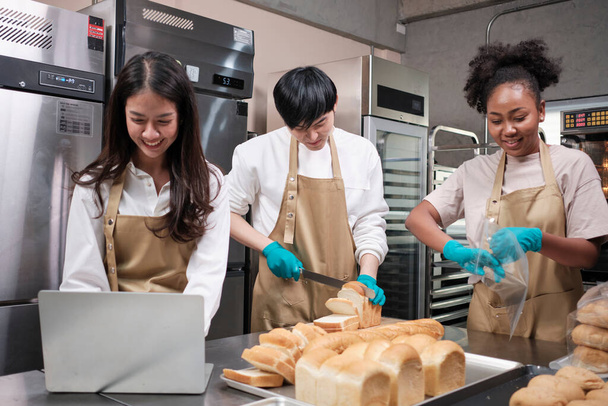 Drie jonge vrienden en startup partners van brood deeg en gebak voedsel bezig met zelfgemaakte bakken banen tijdens het koken van bestellingen online, verpakking, en het leveren op bakkerij winkel, kleine onderneming ondernemer. - Foto, afbeelding