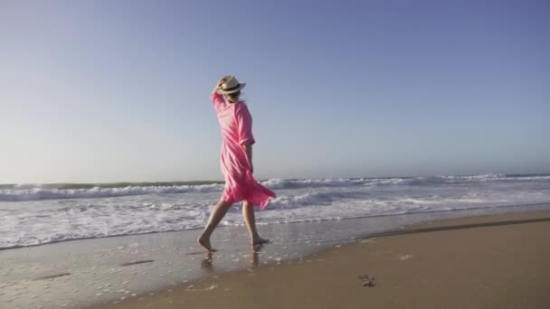 Silhouette donna in volo in abito rosa vento al tramonto alzando la testa in aria - Filmati, video