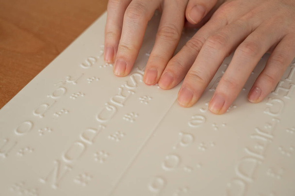 A woman learns the Braille alphabet using a decoder. - Фото, зображення