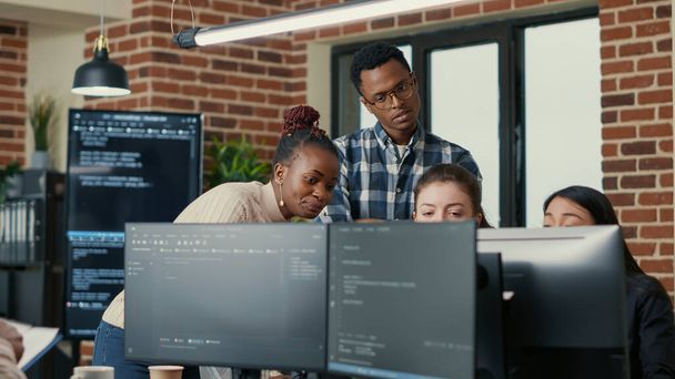 Développeurs idées de remue-méninges regardant le code sur les écrans d'ordinateur demandant des commentaires du développeur principal - Photo, image
