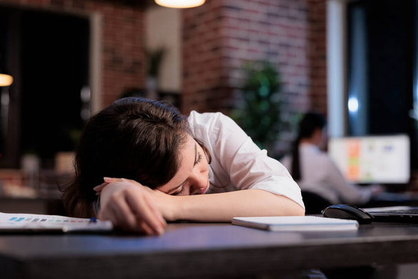 Tired office worker with burnout syndrome sleeping at work because of extreme fatigue. - Photo, Image