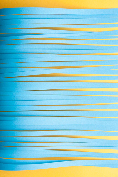Minimalistisch gesneden papier stipt de achtergrond in blauwe en gele kleuren. - Foto, afbeelding