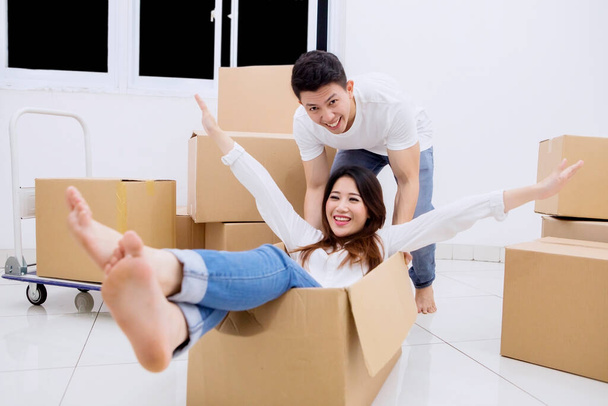 Young couple having fun during unpacking boxes while moving into a new house - Zdjęcie, obraz