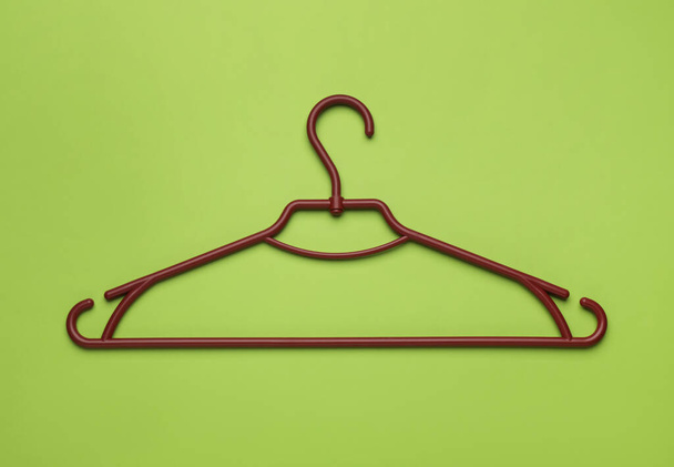 Empty clothes hanger on green background, top view - Fotografie, Obrázek