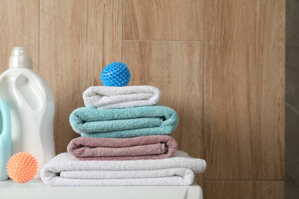 Dryer balls, stacked clean towels and detergents on washing machine. Space for text - Fotoğraf, Görsel