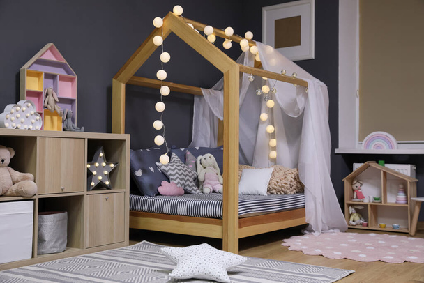 Stylish child room interior with comfortable bed - 写真・画像