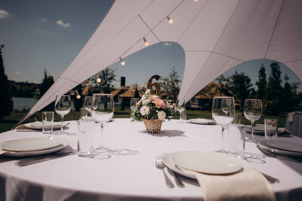 juhla-aterian kattaminen valkoisen teltan alla nurmikolla - Valokuva, kuva