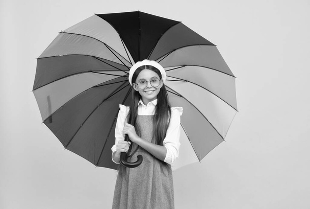 happy teen girl in glasses under colorful umbrella for rain protection in autumn season, optimist. - Фото, зображення
