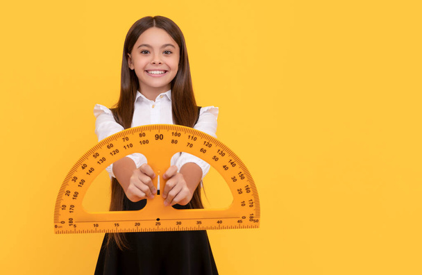 niño alegre en uniforme escolar celebrar transportador de matemáticas para medir, escuela secundaria - Foto, Imagen