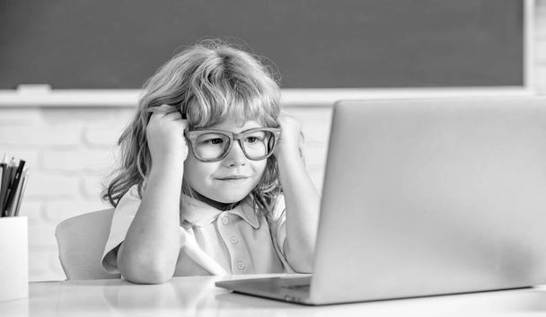Dia do conhecimento. conceito de educação online. Um miúdo totó de óculos com portátil. 1 de Setembro - Foto, Imagem