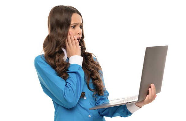 shocked child long curly hair typing on laptop isolated on white, education - Photo, image