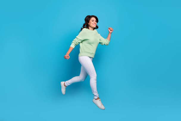 Full body photo of cute mature brunette lady run wear shirt pants footwear isolated on blue background - Foto, Imagen