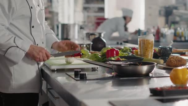 Αρσενικό μάγειρα προετοιμασία σκόρδο για να προσθέσετε σε αρωματική συνταγή τροφίμων - Πλάνα, βίντεο