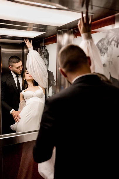 bride and groom posing in the lift - Fotografie, Obrázek