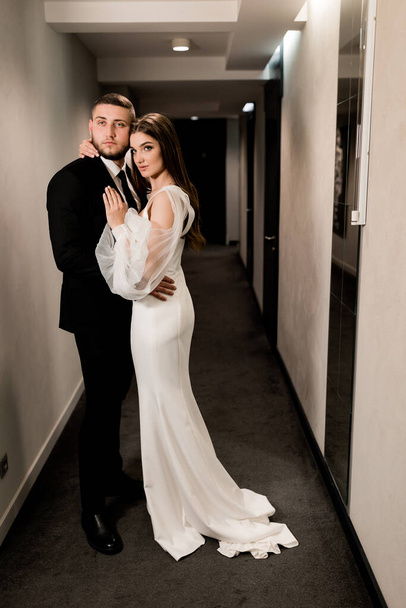 beautiful bride and groom posing in the hallway - Foto, Imagen
