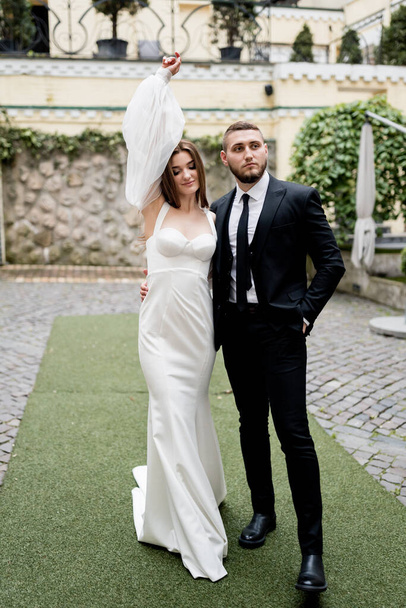 bride and groom posing outdoors on their wedding day - Photo, image